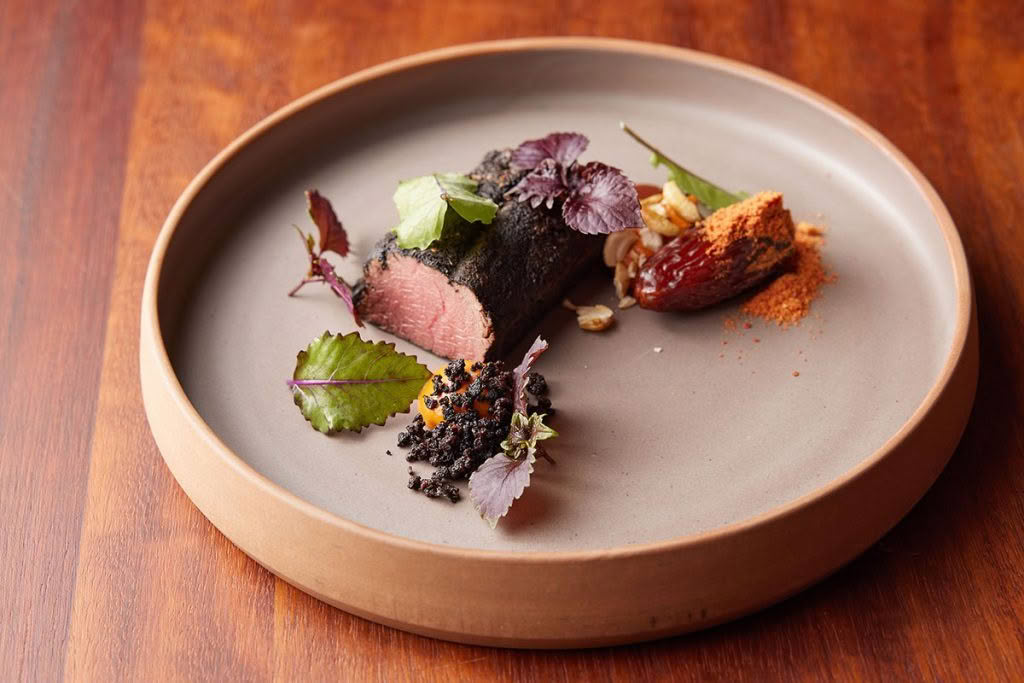 Cuisine-Good-Food-Guide-2024-Sid-at-The-French-Café-Venison,-romesco,-black-pudding,-medjool-date,-smoked-cashews-credit-Josh-Griggs